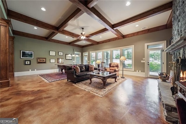 living area with a fireplace, concrete flooring, baseboards, and beam ceiling