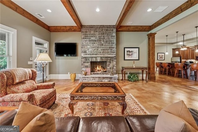 living area featuring decorative columns, visible vents, recessed lighting, a fireplace, and beamed ceiling
