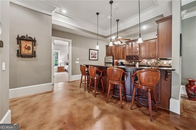kitchen featuring ornamental molding, dark countertops, concrete floors, and decorative backsplash