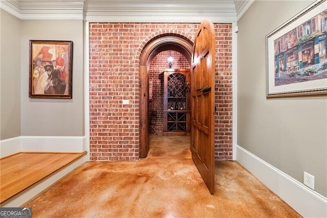 wine room featuring brick wall, crown molding, and carpet floors