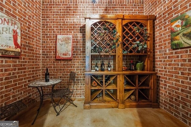 wine cellar featuring brick wall and concrete flooring