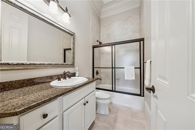 bathroom with tile patterned floors, toilet, enclosed tub / shower combo, and vanity