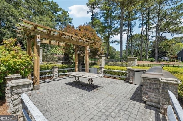 view of patio featuring an outdoor kitchen, a pergola, and fence