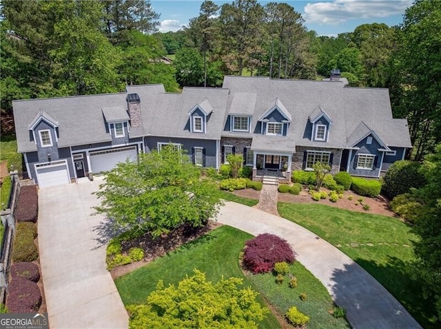 cape cod home featuring an attached garage, driveway, and a chimney