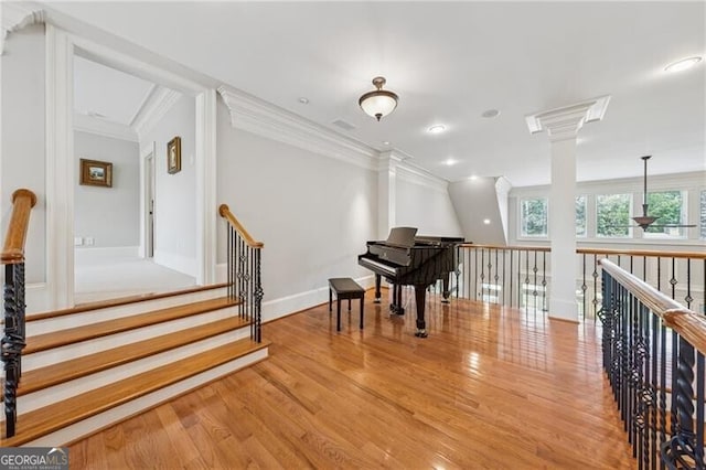living area with baseboards, crown molding, and wood finished floors