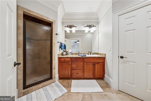 bathroom featuring double vanity, a stall shower, a sink, crown molding, and tile patterned floors