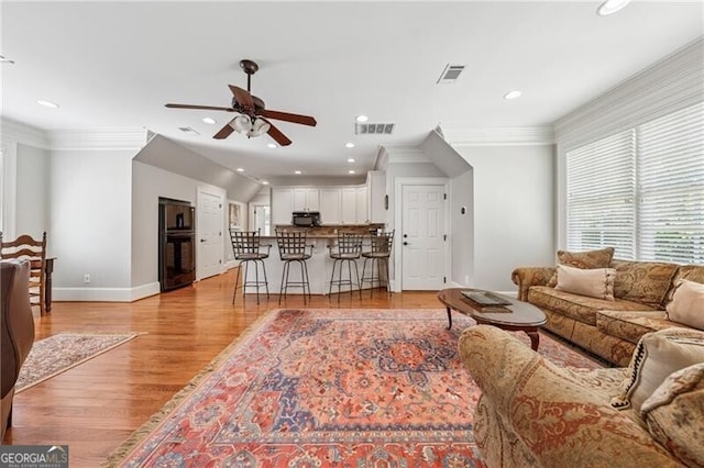living area featuring ceiling fan, light wood finished floors, visible vents, and recessed lighting