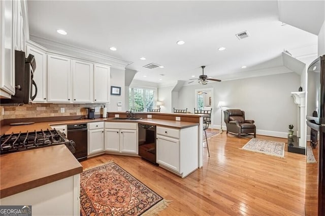 kitchen with a sink, black dishwasher, open floor plan, visible vents, and ceiling fan