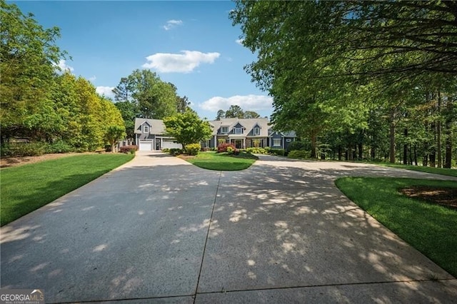 view of front facade with a front lawn, a garage, and curved driveway