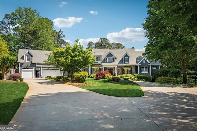 cape cod home featuring driveway, a front yard, and a garage