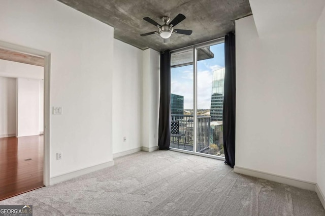 950 W Peachtree St NW Unit 1214, Atlanta, GA 30309 - spare room featuring carpet flooring, a wall of windows, baseboards, and ceiling fan