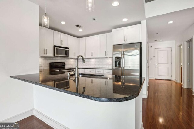 950 W Peachtree St NW Unit 1214, Atlanta, GA 30309 - kitchen featuring baseboards, visible vents, a sink, a peninsula, and stainless steel appliances