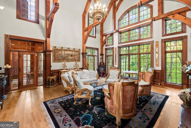 3863 Streamside Dr SE, Marietta, GA 30067 - living room with an inviting chandelier, wainscoting, a high ceiling, and wood finished floors