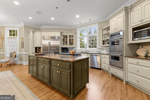 3863 Streamside Dr SE, Marietta, GA 30067 - kitchen with crown molding, plenty of natural light, built in appliances, and a center island with sink
