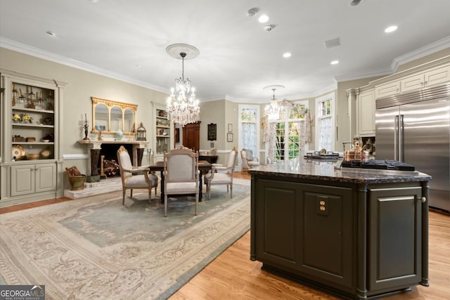 3863 Streamside Dr SE, Marietta, GA 30067 - kitchen featuring light wood finished floors, an inviting chandelier, a center island, crown molding, and built in fridge