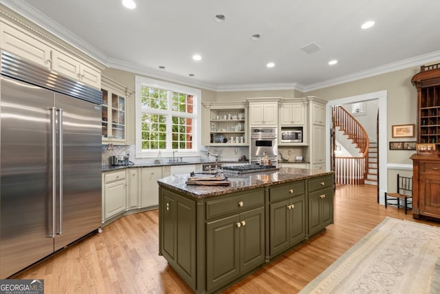 3863 Streamside Dr SE, Marietta, GA 30067 - kitchen with light wood-style floors, a kitchen island, built in appliances, and ornamental molding