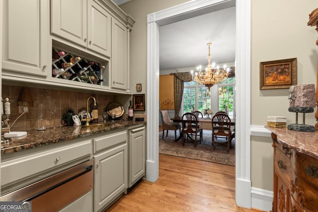 3863 Streamside Dr SE, Marietta, GA 30067 - bar with a wainscoted wall, a notable chandelier, a warming drawer, light wood-style floors, and decorative backsplash