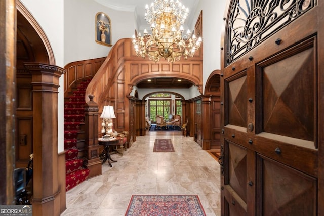 3863 Streamside Dr SE, Marietta, GA 30067 - entryway featuring crown molding, stairway, a towering ceiling, arched walkways, and a chandelier