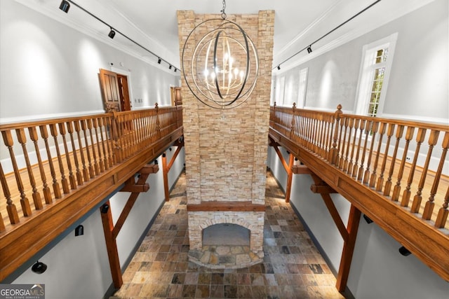 3863 Streamside Dr SE, Marietta, GA 30067 - hall featuring rail lighting, ornamental molding, stone finish flooring, and a chandelier