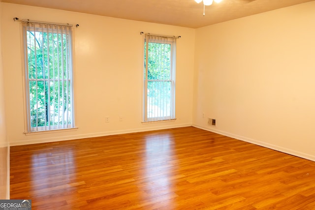 spare room with baseboards, ceiling fan, and wood finished floors