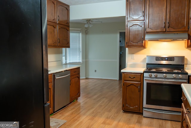kitchen featuring under cabinet range hood, light countertops, stainless steel appliances, and a ceiling fan