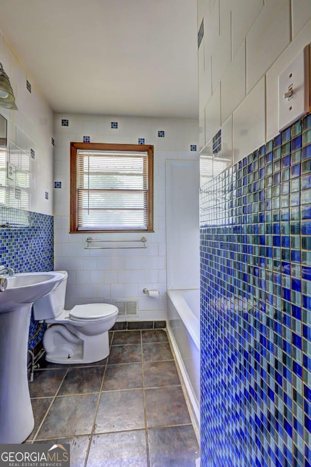 1815 Windsor Dr SW, Atlanta, GA 30311 - bathroom featuring tile walls, toilet, walk in shower, visible vents, and a tub