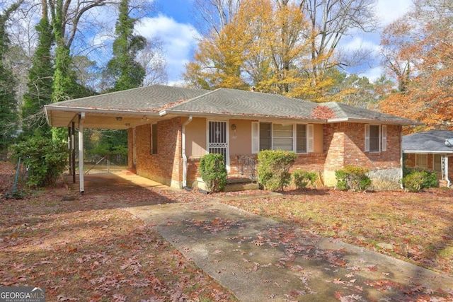 1815 Windsor Dr SW, Atlanta, GA 30311 - view of front facade featuring concrete driveway, brick siding, covered porch, and a carport