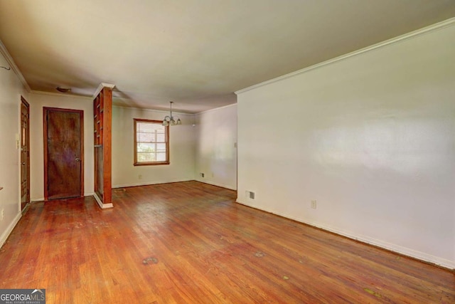 1815 Windsor Dr SW, Atlanta, GA 30311 - unfurnished living room with baseboards, ornamental molding, an inviting chandelier, and wood finished floors