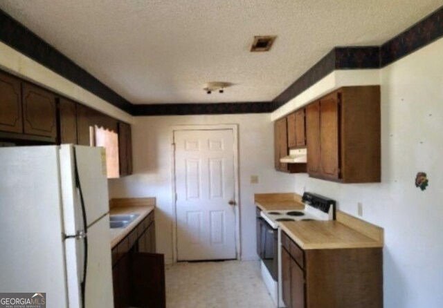 540 Veneys Mill Pond Rd, Parrott, GA 39877 - kitchen featuring white appliances, a textured ceiling, visible vents, under cabinet range hood, and light countertops