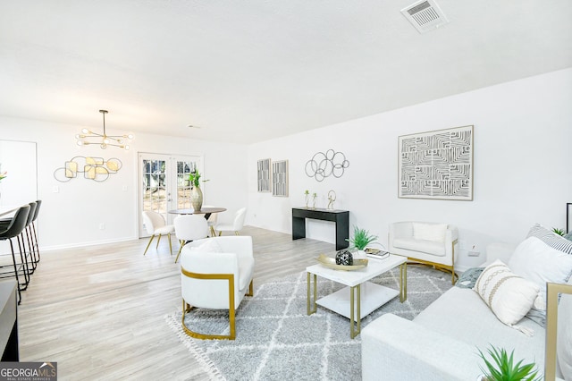8479 Alden Dr, Riverdale, GA 30274 - living area featuring light wood finished floors, visible vents, baseboards, and a chandelier
