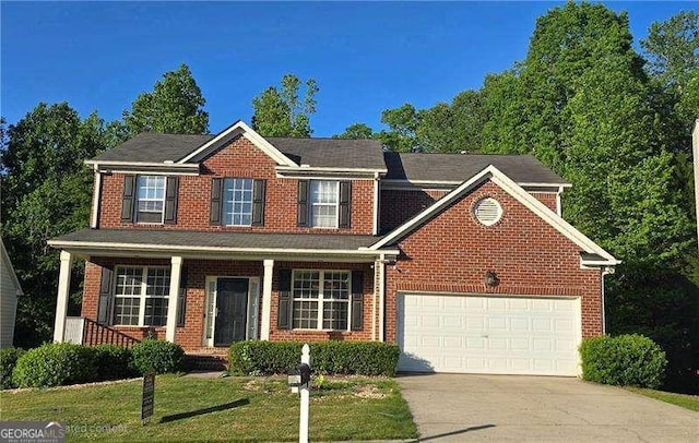 7491 Hilltop Way, Atlanta, GA 30349 - view of front of home with concrete driveway, brick siding, an attached garage, a porch, and a front lawn