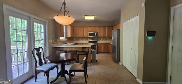7491 Hilltop Way, Atlanta, GA 30349 - kitchen with stainless steel appliances, backsplash, healthy amount of natural light, and light tile patterned floors