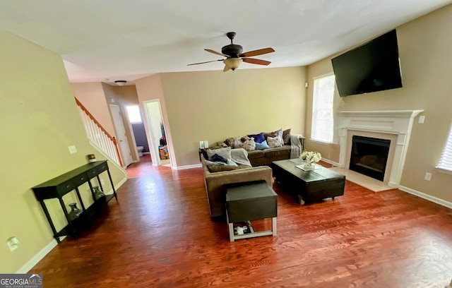 7491 Hilltop Way, Atlanta, GA 30349 - living room with wood finished floors, a ceiling fan, a fireplace with flush hearth, and stairway
