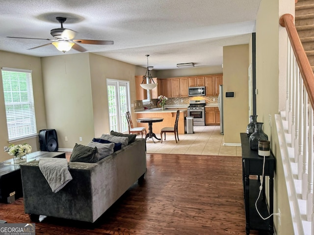 7491 Hilltop Way, Atlanta, GA 30349 - living room featuring a ceiling fan, stairs, a textured ceiling, and light wood-type flooring