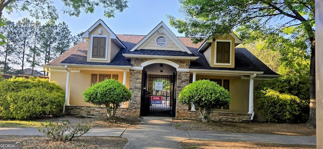 7491 Hilltop Way, Atlanta, GA 30349 - view of front of property with stucco siding, stone siding, a gate, and roof with shingles