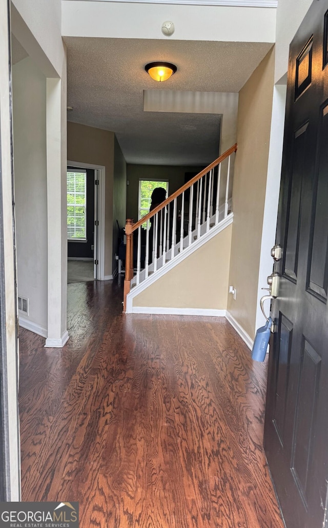 7491 Hilltop Way, Atlanta, GA 30349 - foyer entrance with wood finished floors, stairway, and a textured ceiling