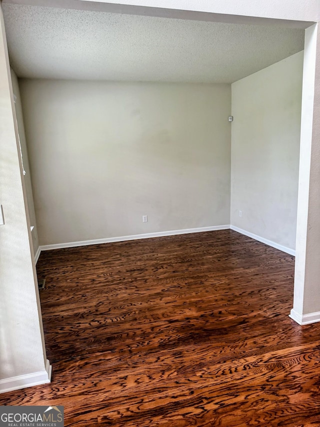 7491 Hilltop Way, Atlanta, GA 30349 - unfurnished room with dark wood-type flooring and a textured ceiling