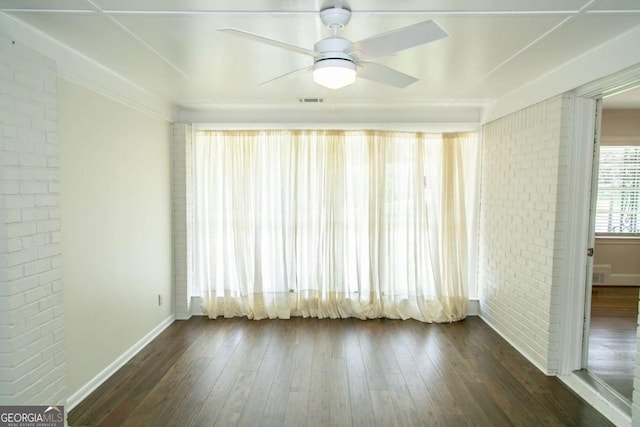 1468 N Amanda Cir, Atlanta, GA 30329 - empty room with visible vents, dark wood finished floors, a ceiling fan, brick wall, and baseboards