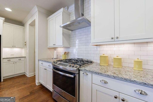 kitchen with white cabinets, wall chimney range hood, stainless steel gas range oven, and tasteful backsplash
