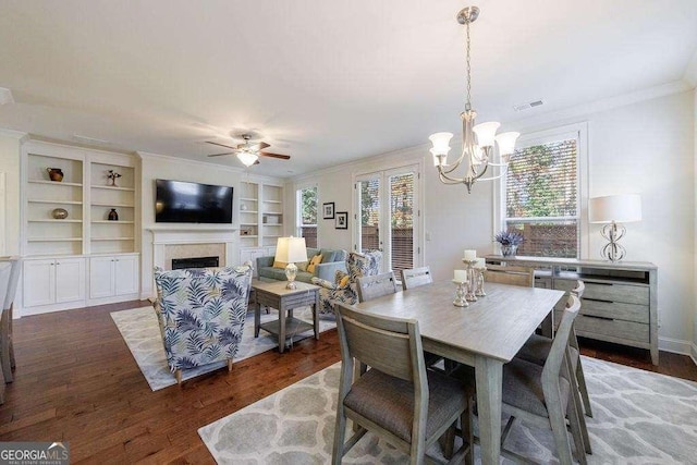 dining room with a fireplace, ornamental molding, a wealth of natural light, and visible vents