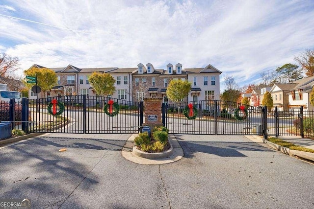 view of gate with fence and a residential view