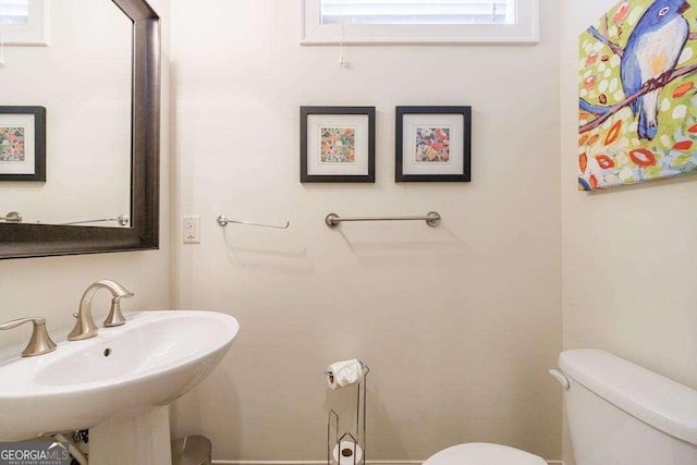 half bathroom featuring toilet and a sink
