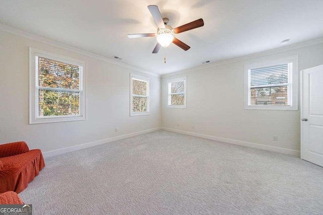 empty room with ornamental molding, baseboards, and a healthy amount of sunlight