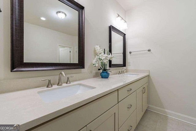 full bathroom featuring baseboards, tile patterned flooring, double vanity, and a sink