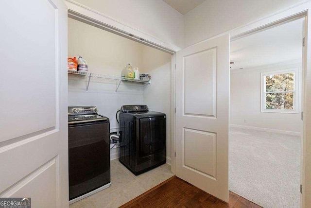 laundry area with baseboards, washing machine and dryer, laundry area, and wood finished floors