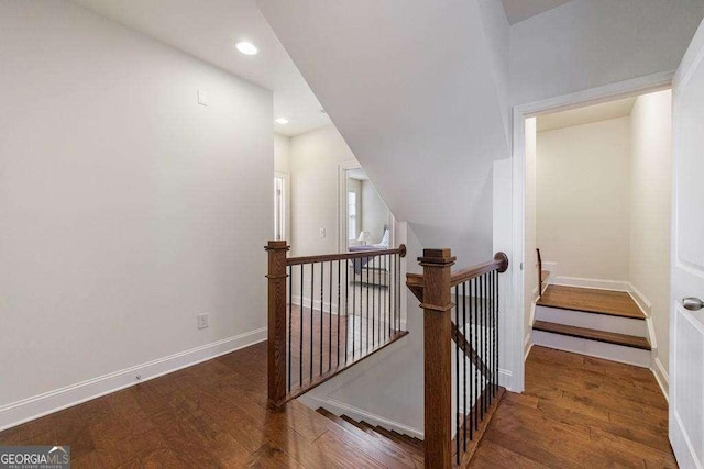 staircase featuring lofted ceiling, recessed lighting, baseboards, and wood finished floors