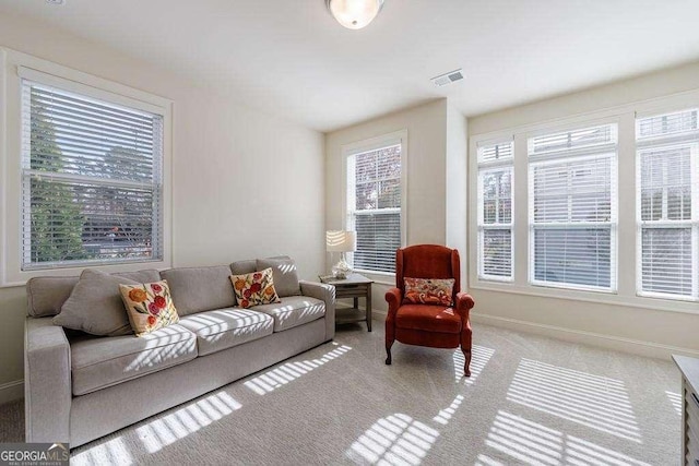 living room with carpet, visible vents, and baseboards
