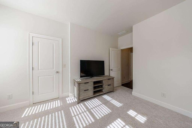 unfurnished living room with light colored carpet, visible vents, and baseboards