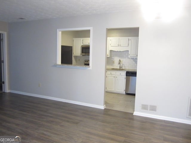 4018 Woodridge Way, Tucker, GA 30084 - unfurnished living room featuring a sink, baseboards, visible vents, and dark wood finished floors