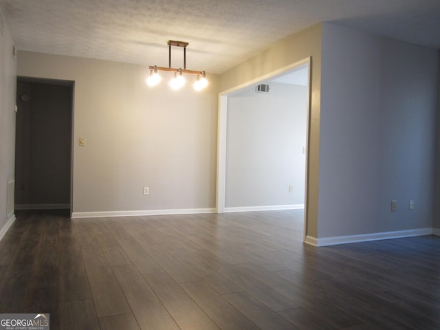 4018 Woodridge Way, Tucker, GA 30084 - spare room featuring baseboards, visible vents, a textured ceiling, and dark wood-type flooring